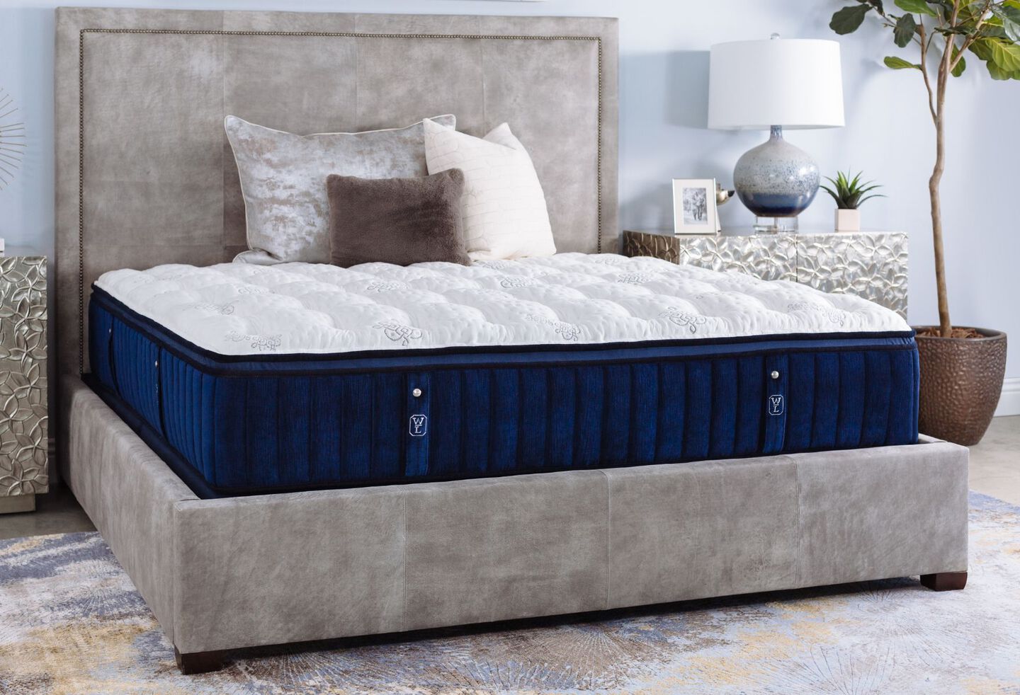 Navy blue and white William & Lawrence mattress with beige and brown pillows on top