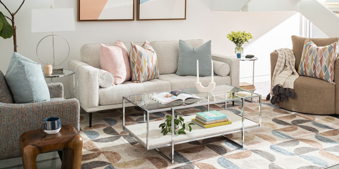 mid-century modern living room with beige couch, silver and white dining table, and colorful rug