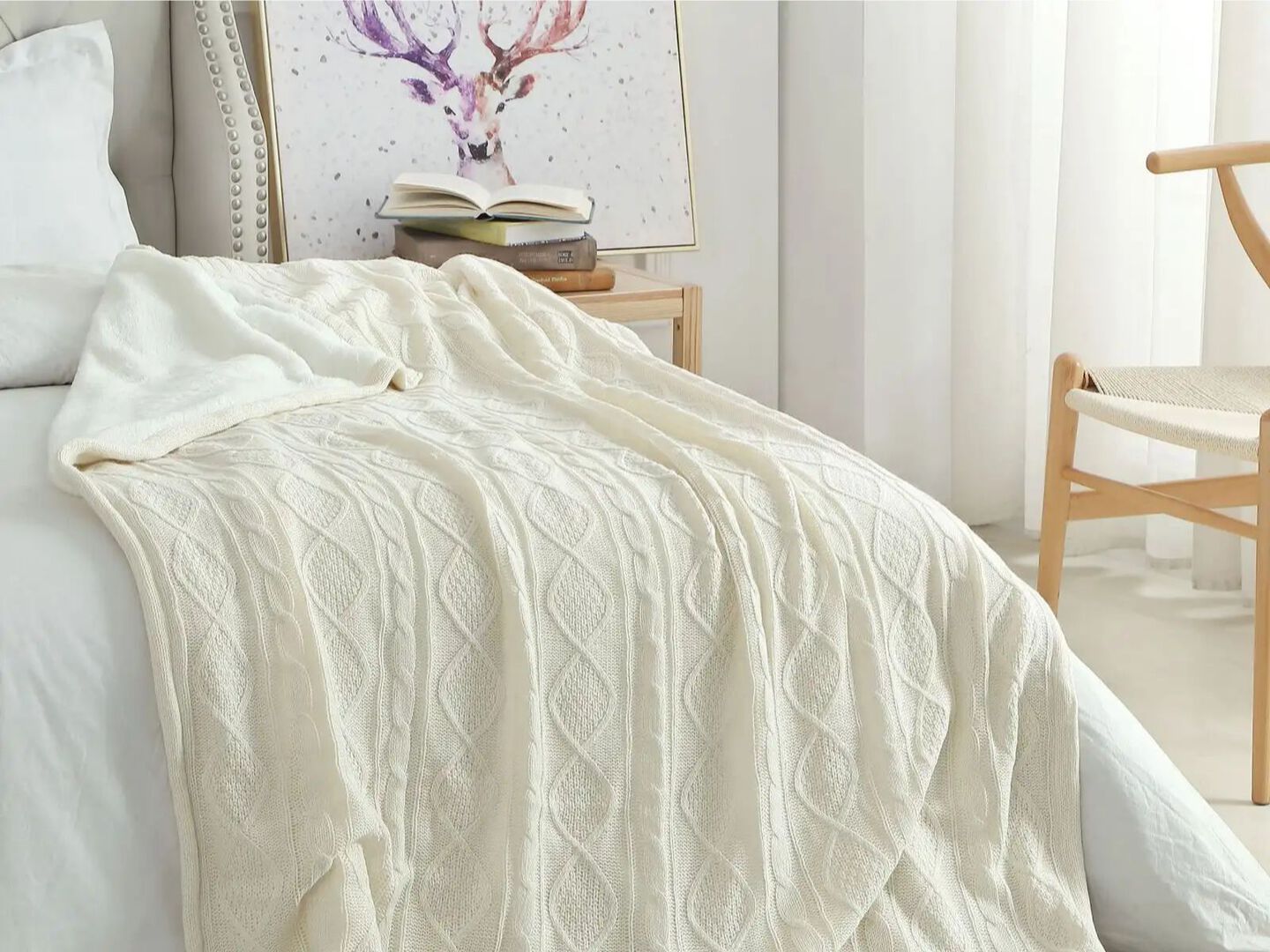 Bed with a white comforter and off white throw blanket on top