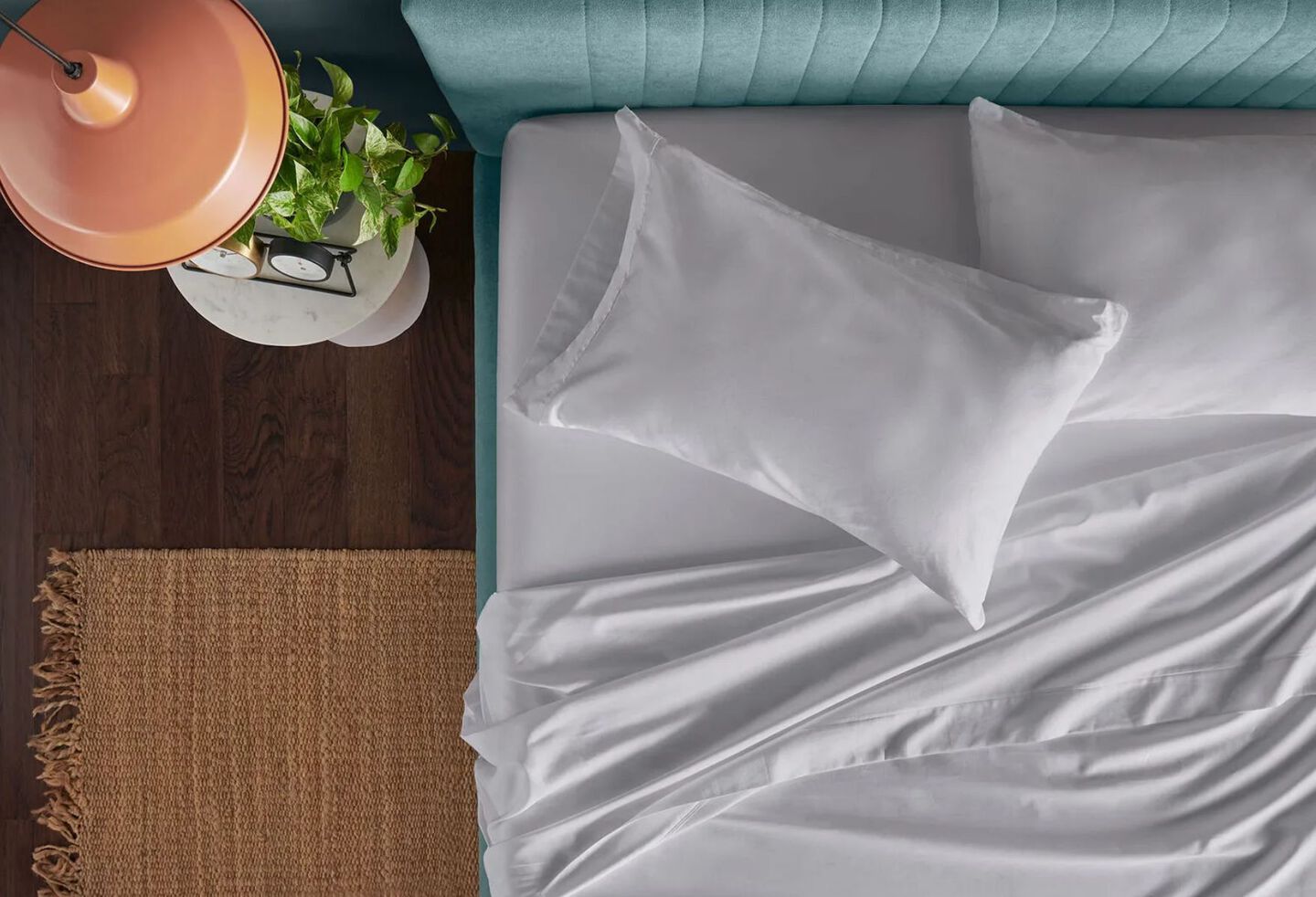 Aerial view of an unmade bed with white pillows and sheets