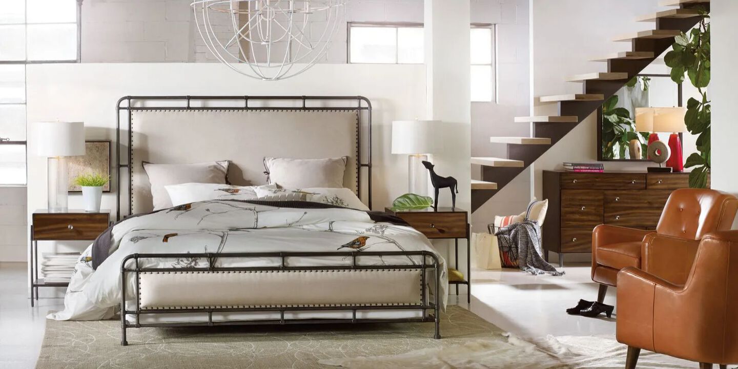 metal framed bed with light beige upholstery and white bedspread
