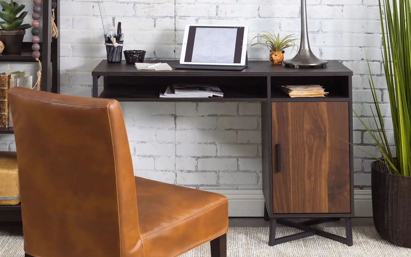 Black and brown metal desk with light brown leather chair in front