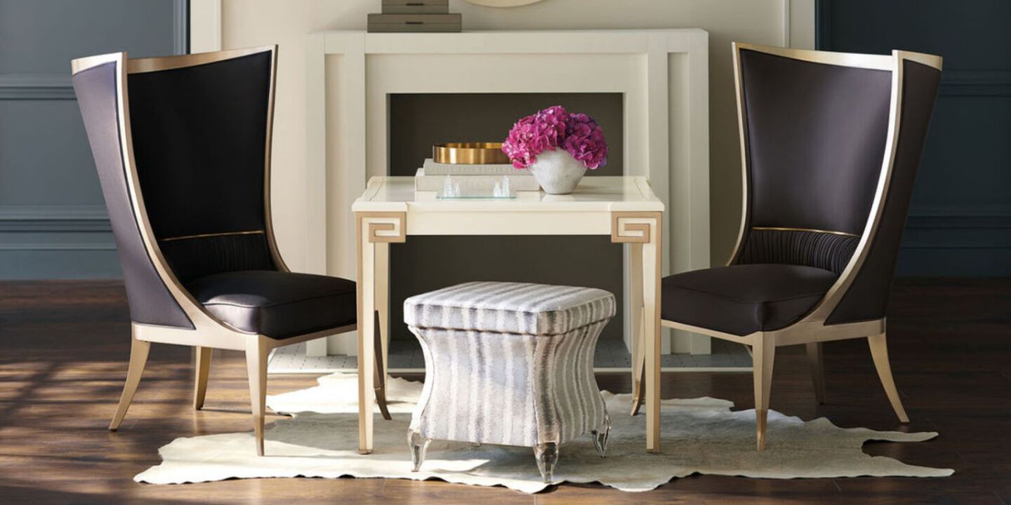 two black dining room chairs surrounding a beige table in the center