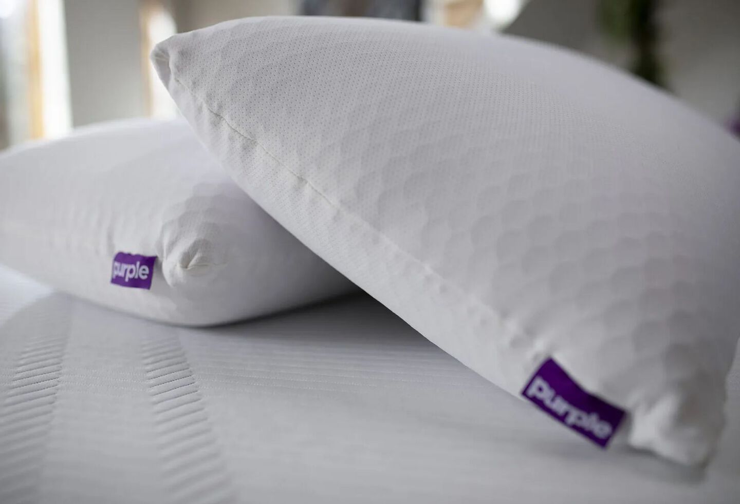 Two Purple brand pillows on top of a white mattress