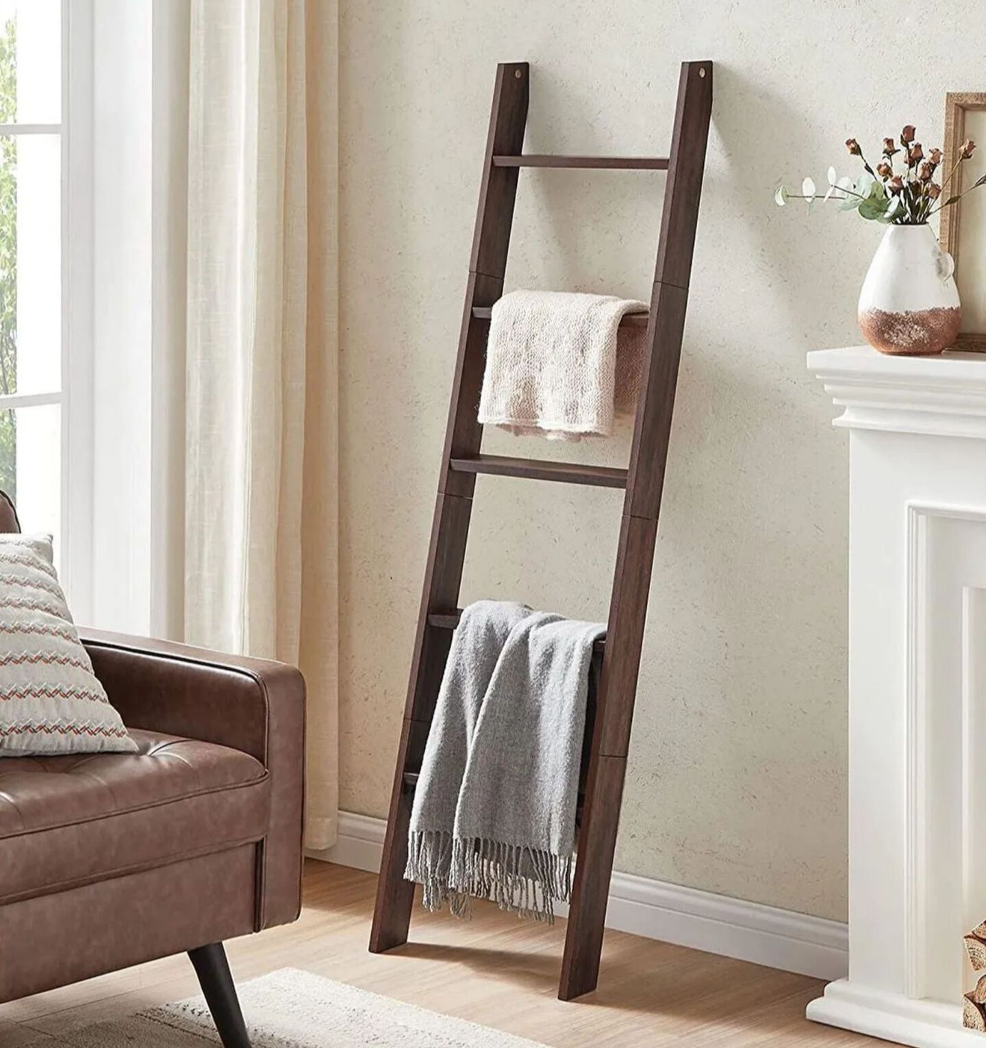 Living room with brown couch and blanket ladder with two blankets hanging on top