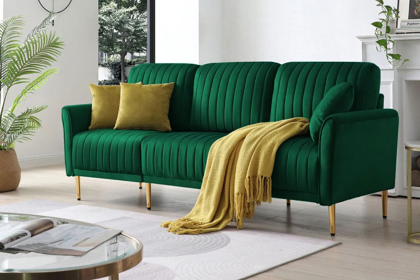 Emerald green couch with yellow pillows and blanket draped over it