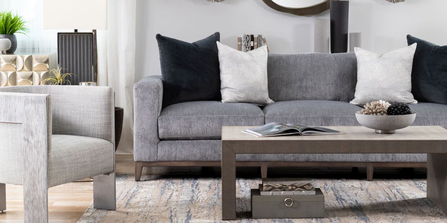living room with dark grey sofa, light grey chair, and tan coffee table