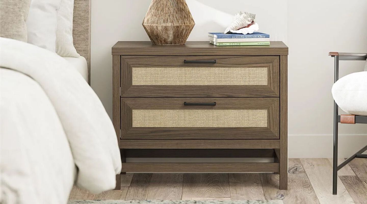 Black and beige nightstand in a bedroom sitting next to a white bed