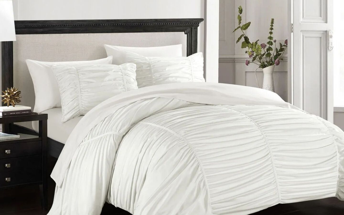 Bed with black bedframe and white textured bedding and matching pillow shams