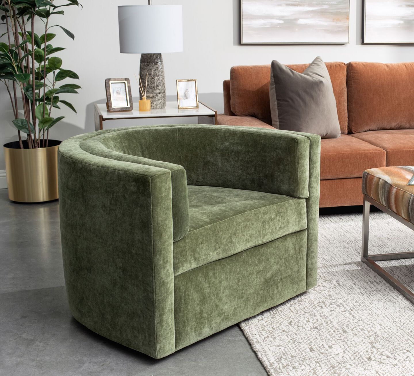 Living room with orange couch and a green velvet accent chair