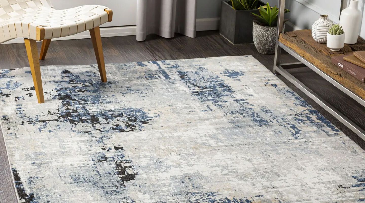 Blue, white, and grey living room rug with a white chair on top