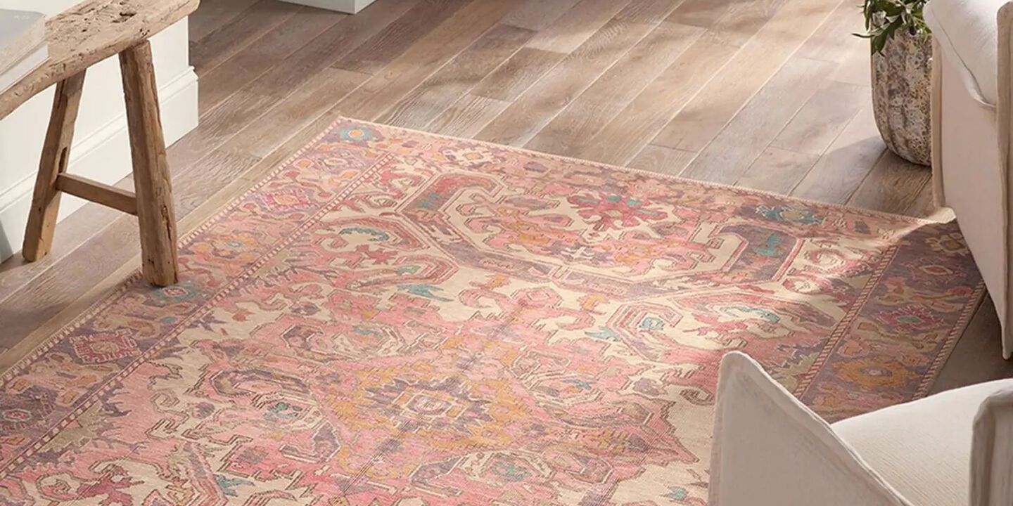 Colorful pink rug on top of hardwood floor