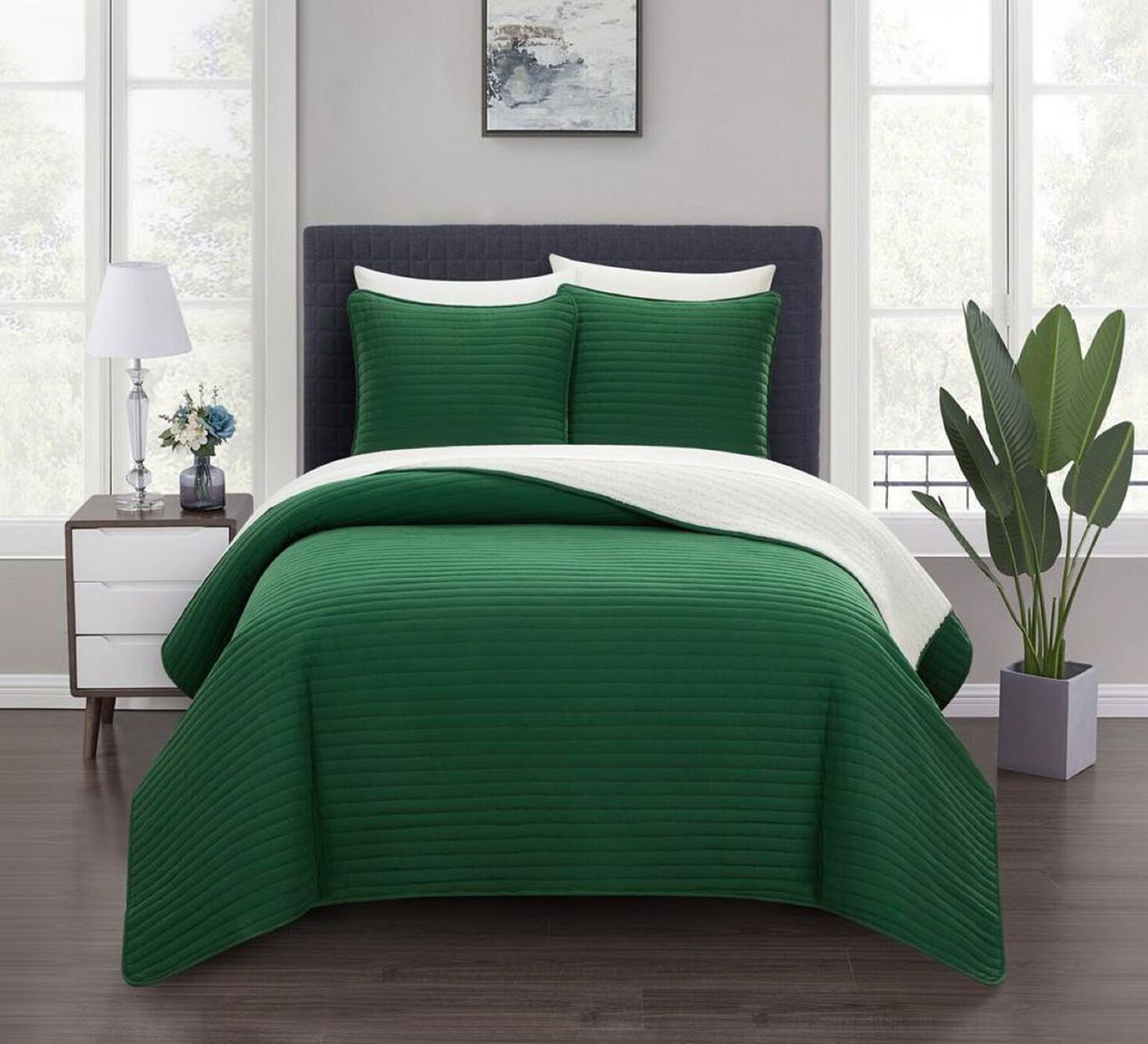 Bed with dark grey bedframe and green and white bedding