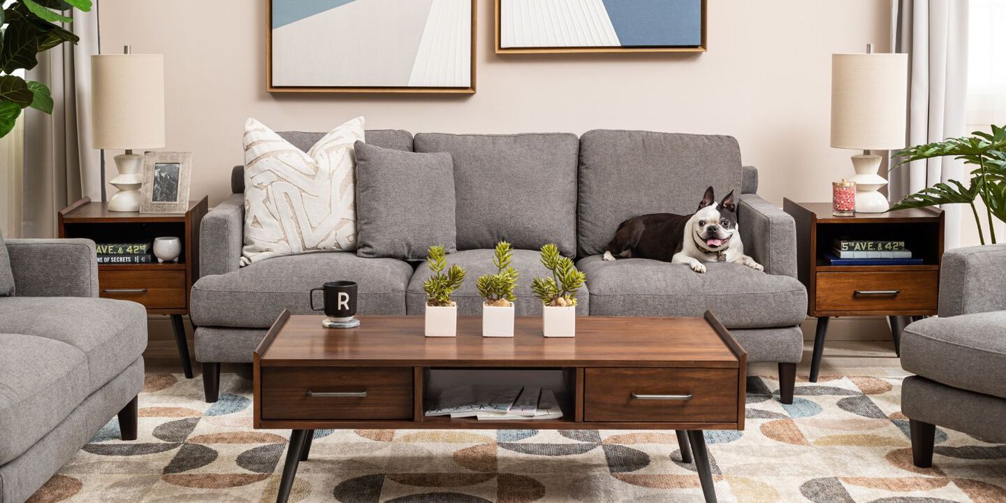 living room with a brown wooden coffee table and a grey couch with a dog sitting atop