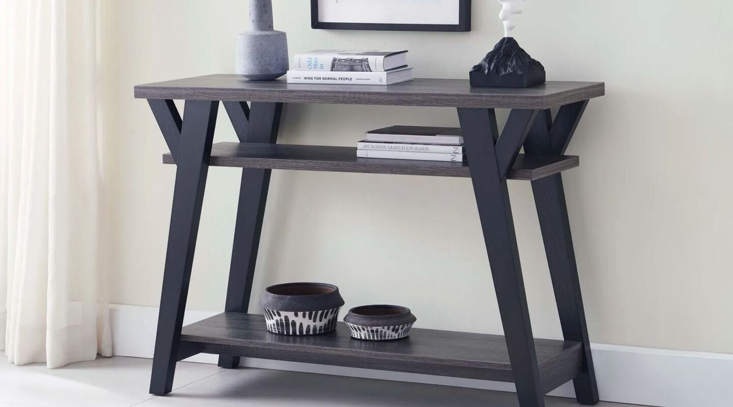 Black and dark grey entryway table with books and vases on top